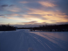 outdoorsman lodging- patten, me- photo of snowmobile trails at dusk